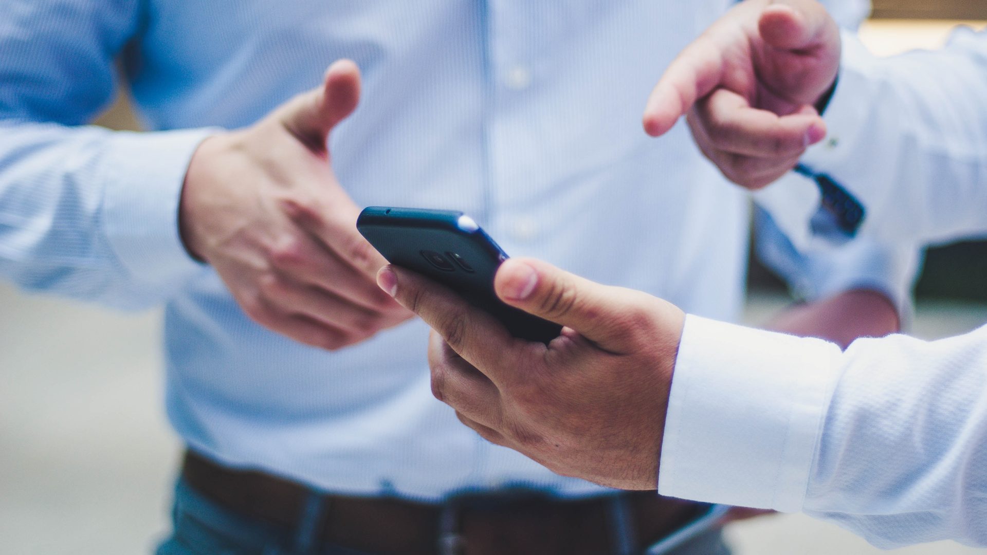 Zwei Geschäftsleute besprechen sich am Smartphone